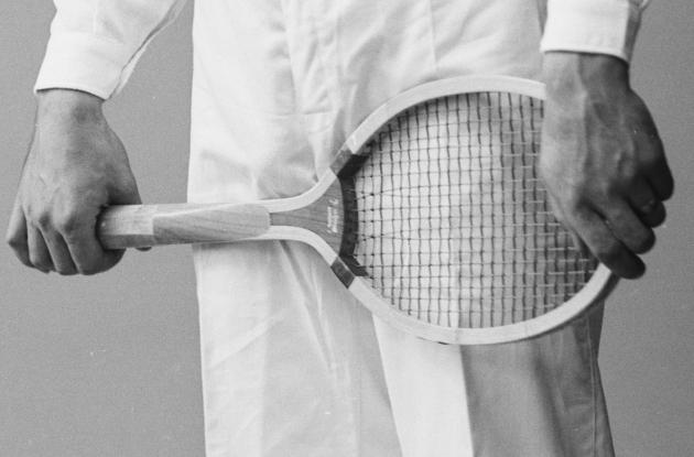 To hænder holder på en tennisketsjer