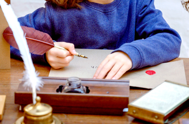 barn skriver med fjerpen