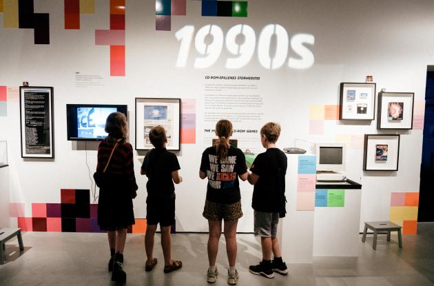 Børn kigger på udstillingsvæg fra DKgame