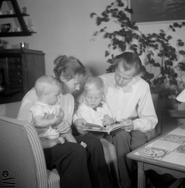 To forældre og to børn ser på et fotoalbum