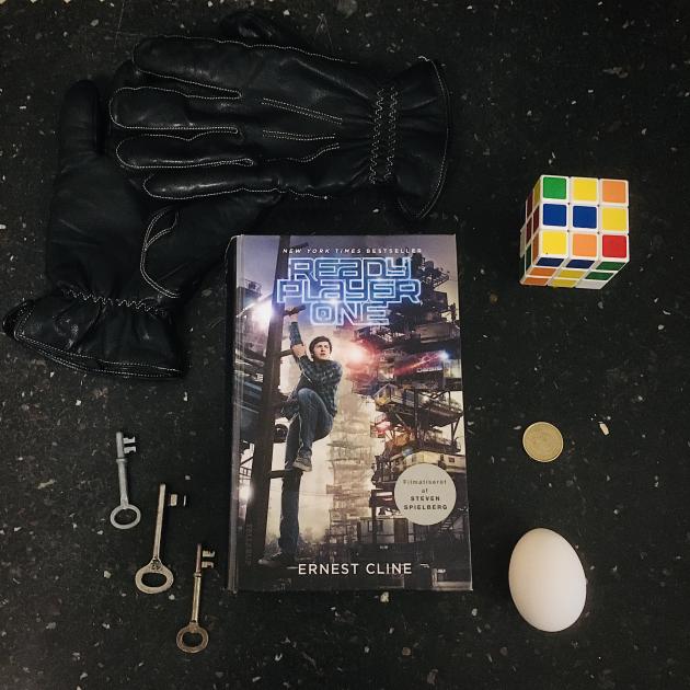 Bogen Ready Player One omringet af en handske, nogle nøgler, et æg og en rubiksterning